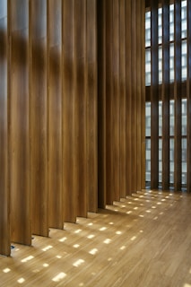 Wooden slats create patterns of light on floor.
