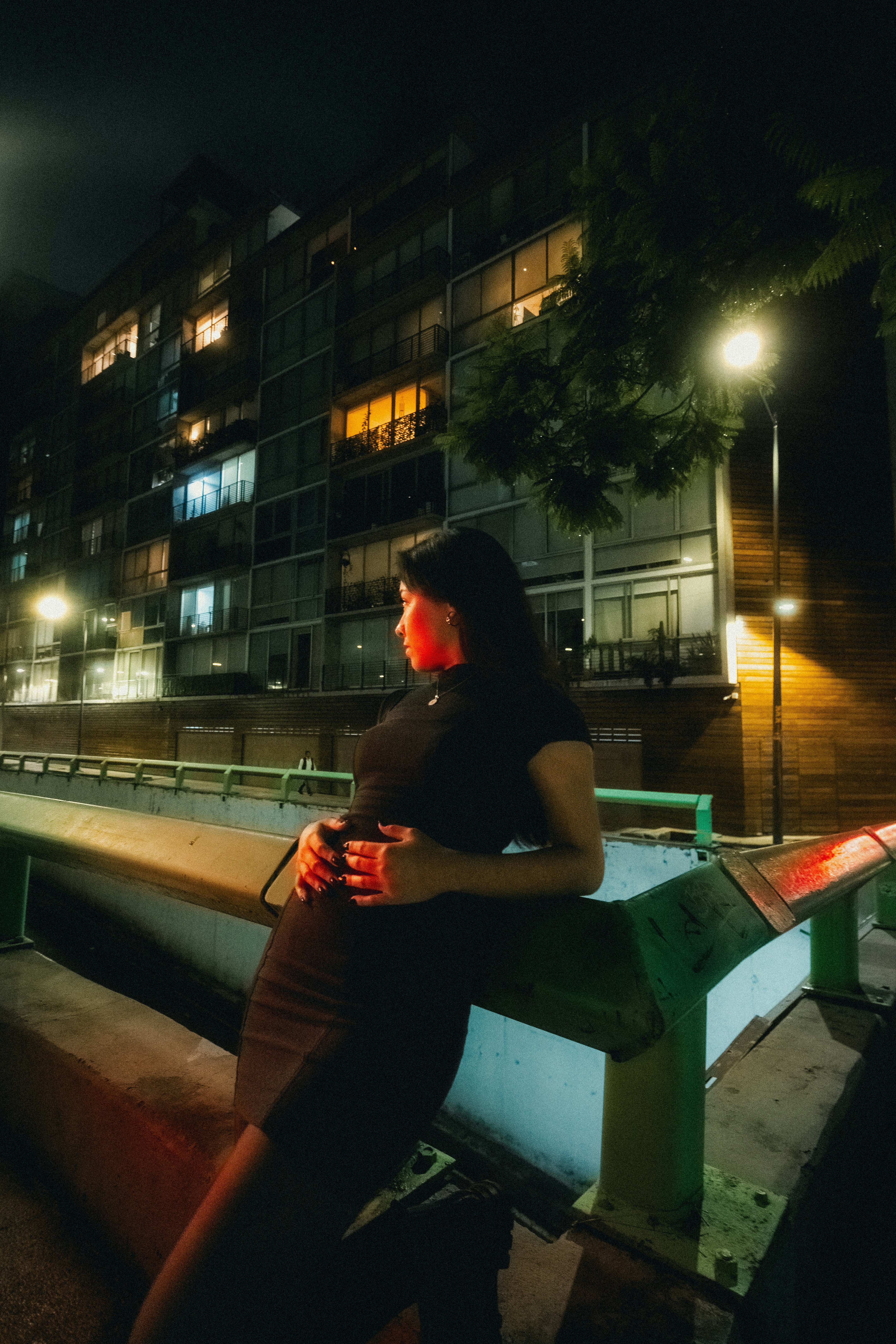Woman in black dress looking away at night