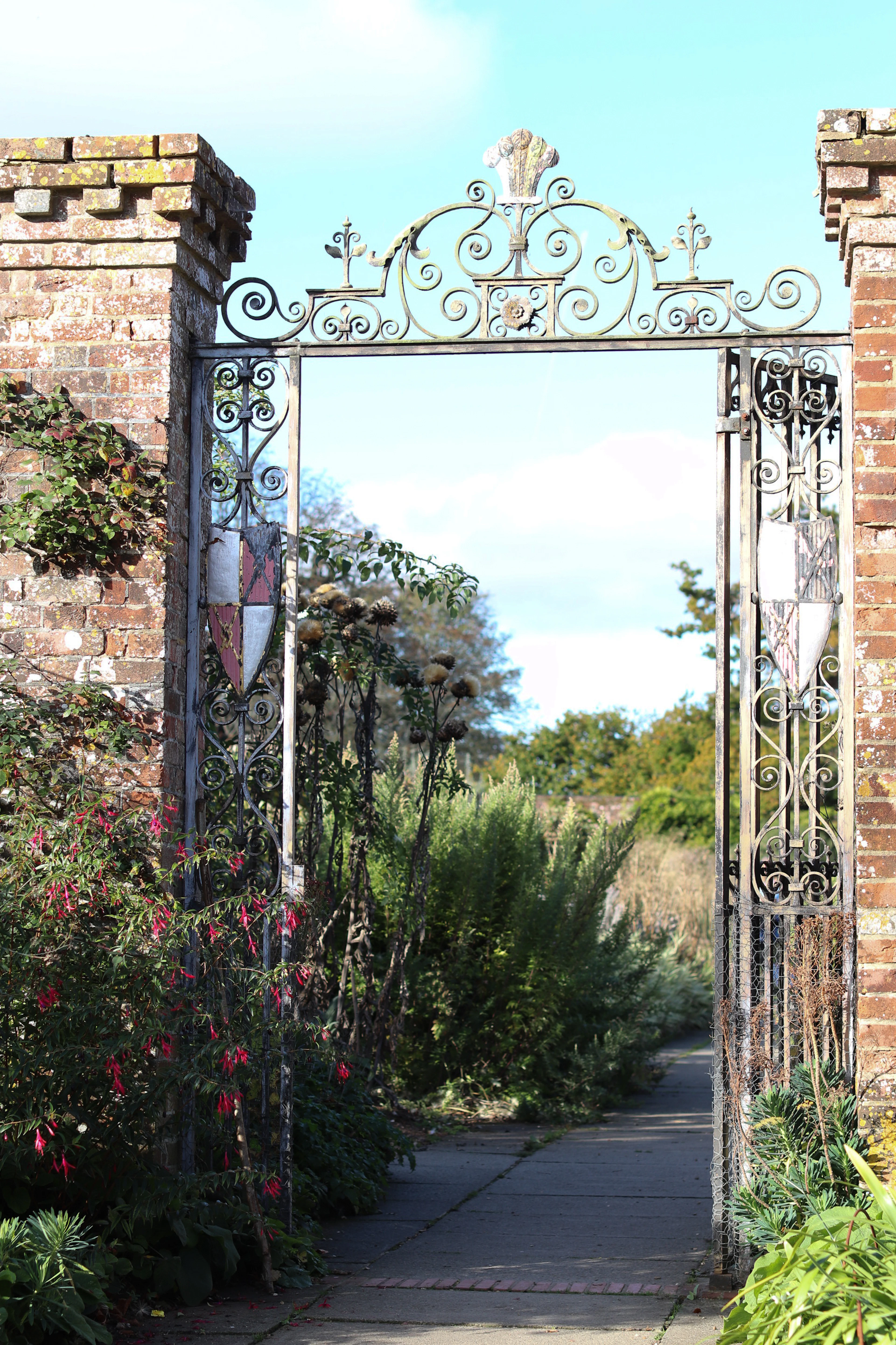 Ornate metal gate opening to a garden path