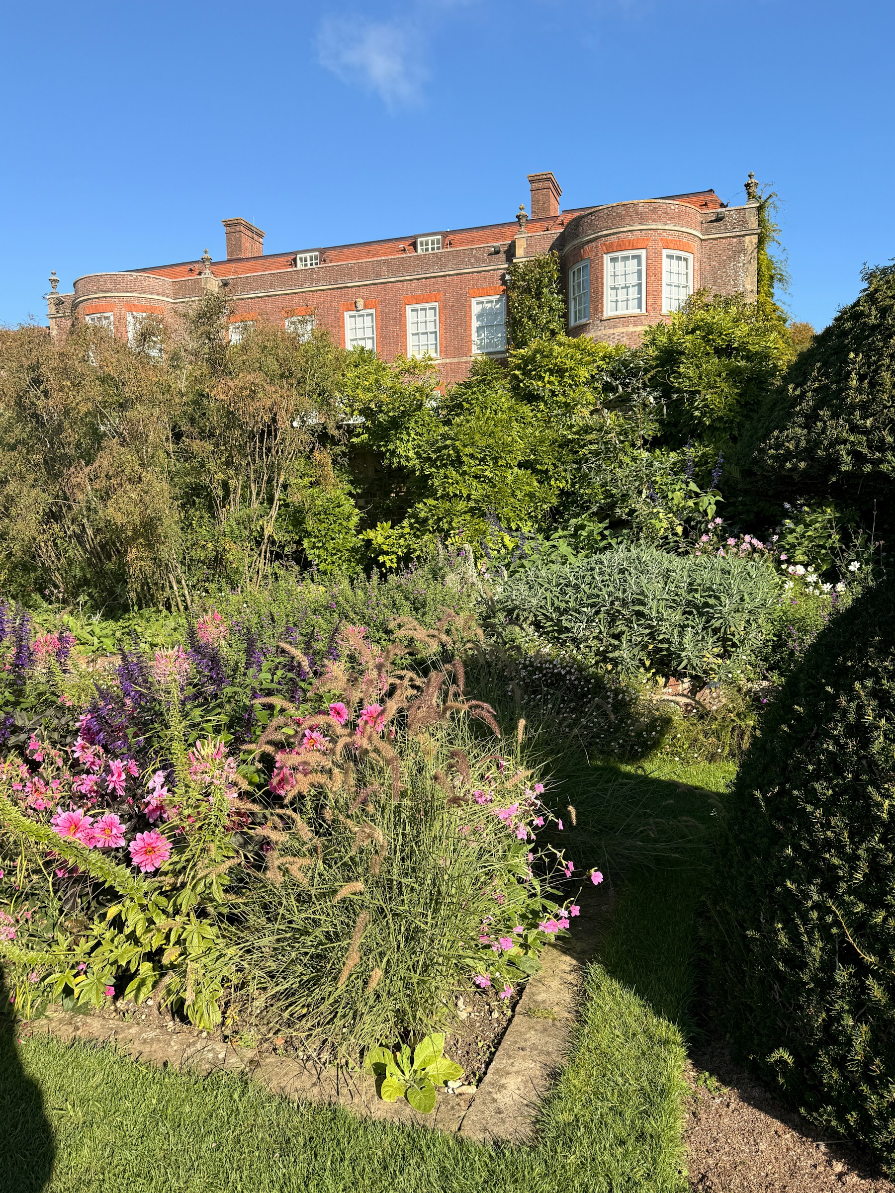 Historic London brick townhouse seen from lush garden