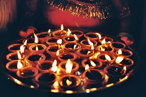 Many lit diyas arranged on a platter