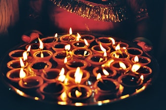 Many lit diyas arranged on a platter