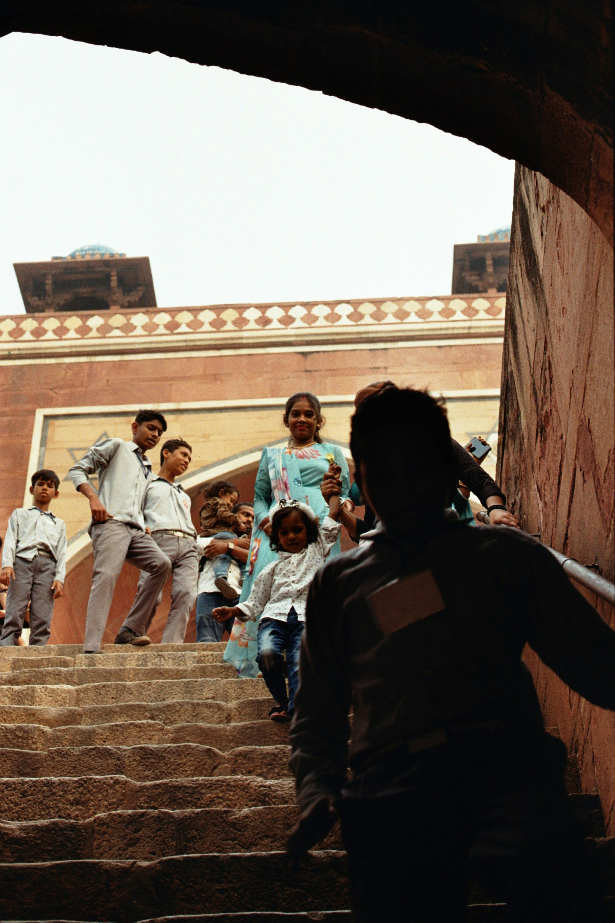 A family descends stone steps towards a building.