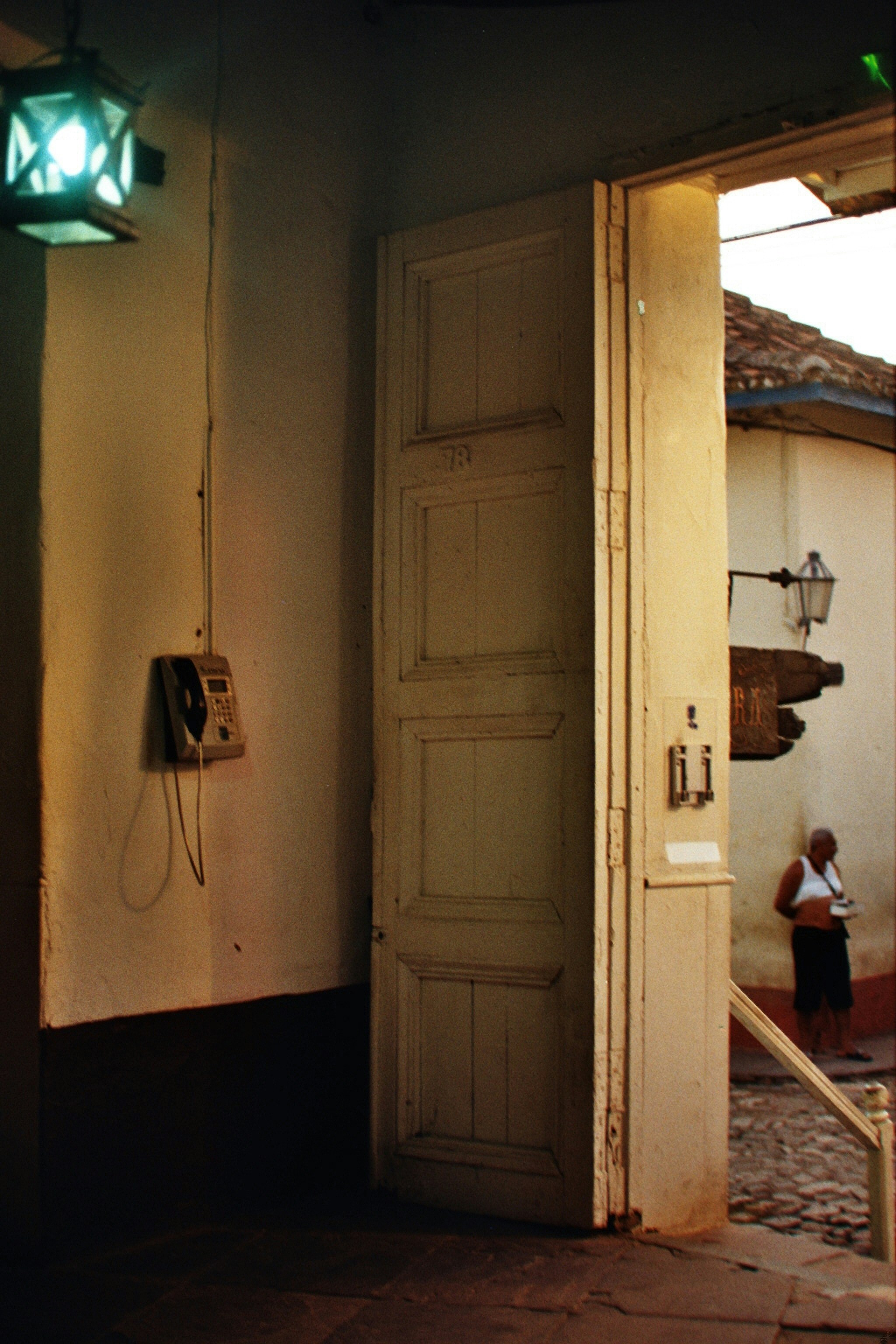 Open doorway with a vintage phone and green lantern.