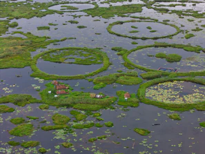 Circular floating islands with huts on a lake