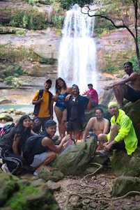 Group of friends gathered by a waterfall