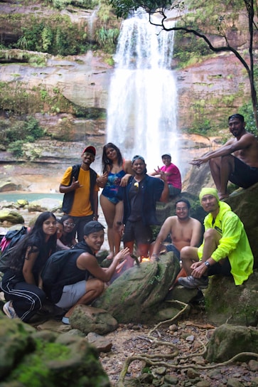 Group of friends gathered by a waterfall