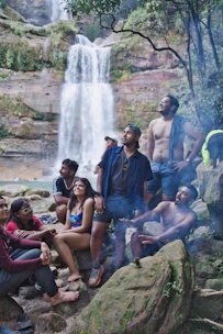 Group of friends enjoying a waterfall picnic