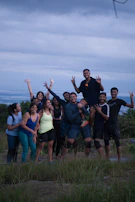 A group of friends posing on a hilltop at sunset