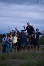 A group of friends posing on a hilltop at sunset