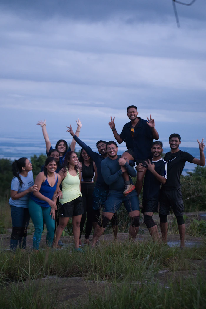 Friends posing on a hilltop at sunset