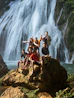 Group of friends posing on rocks near a waterfall