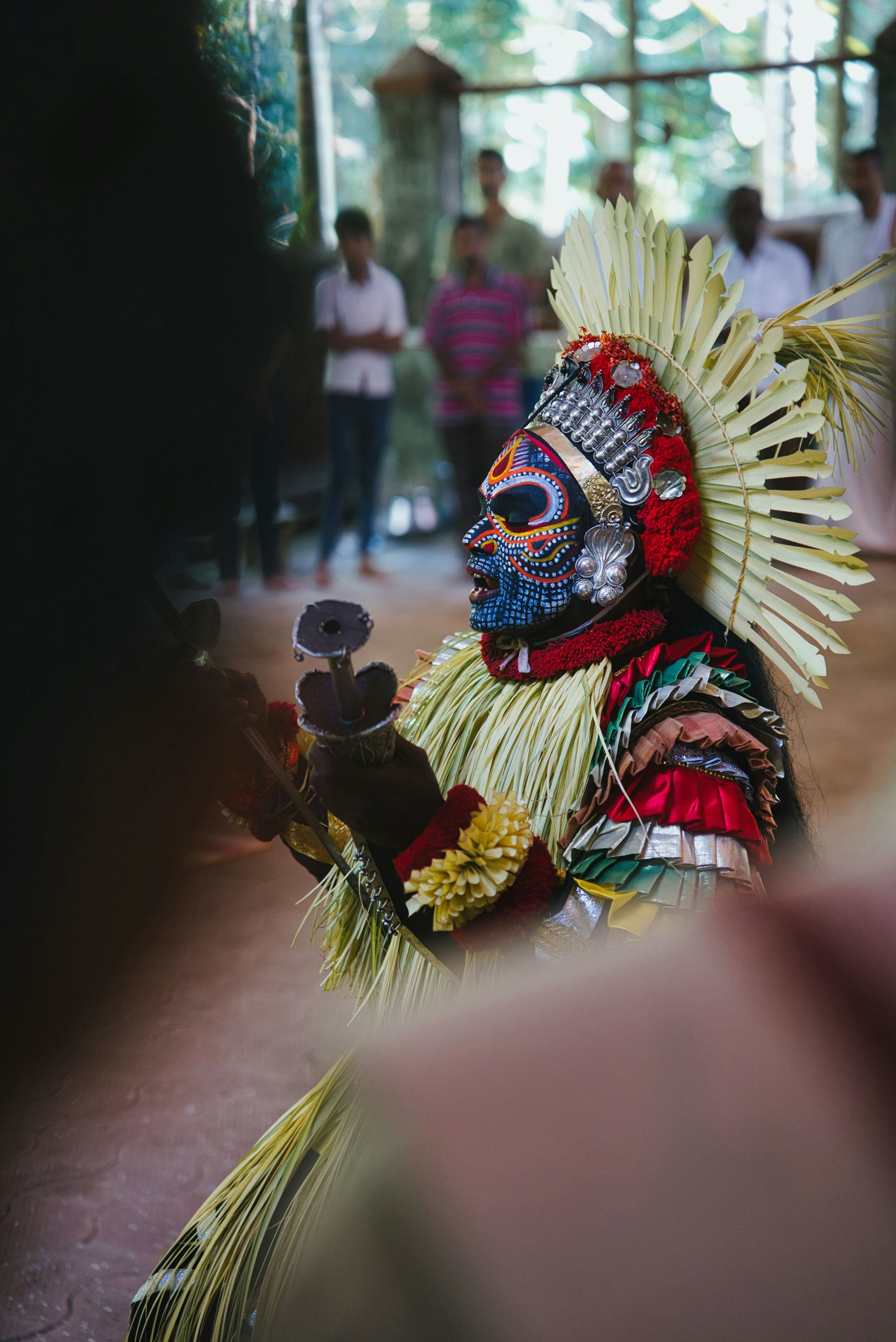 A performer in a colorful traditional costume and mask.