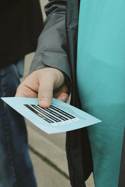 Hand holding a blue flyer with black text