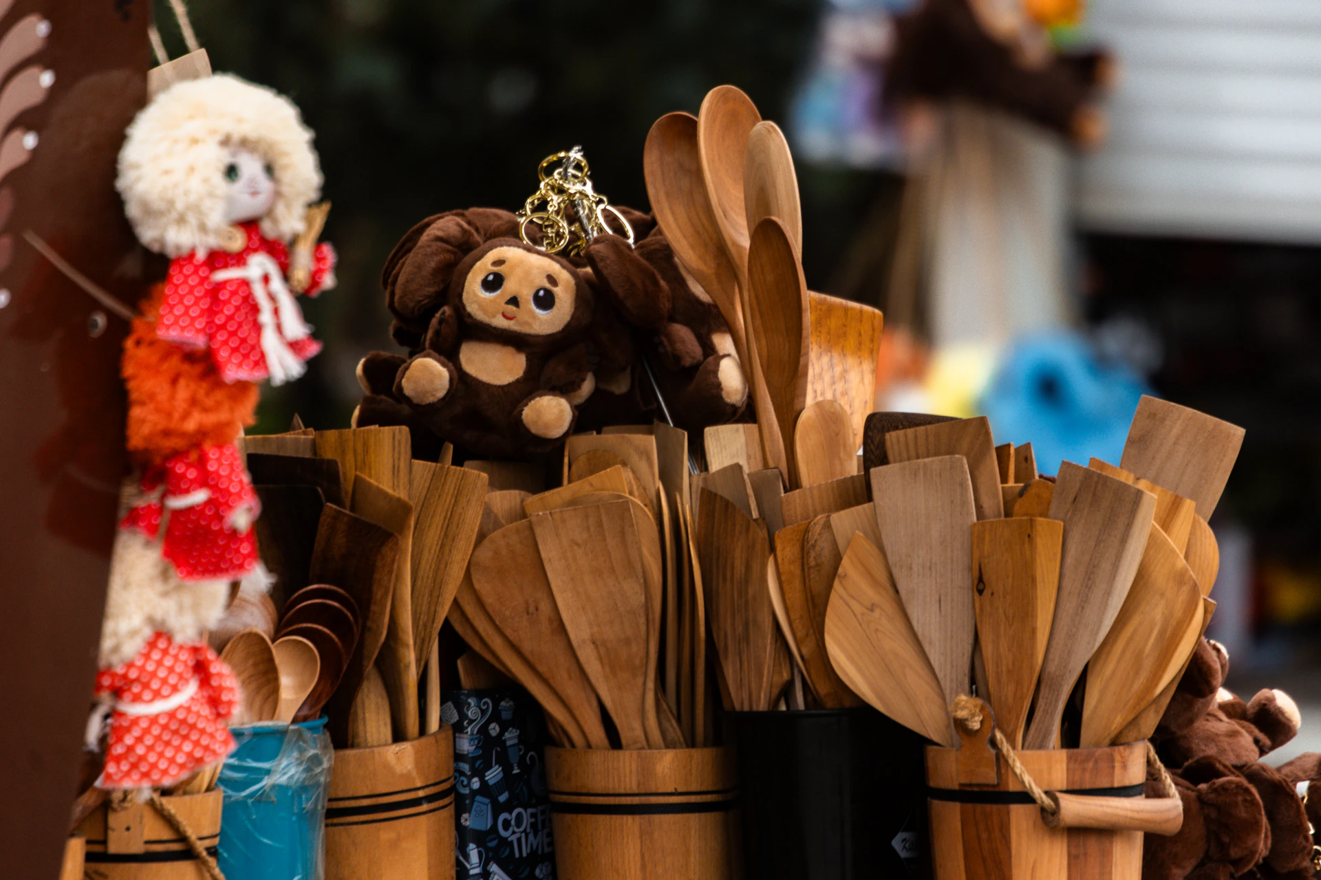 Wooden kitchen utensils and stuffed toys on display.