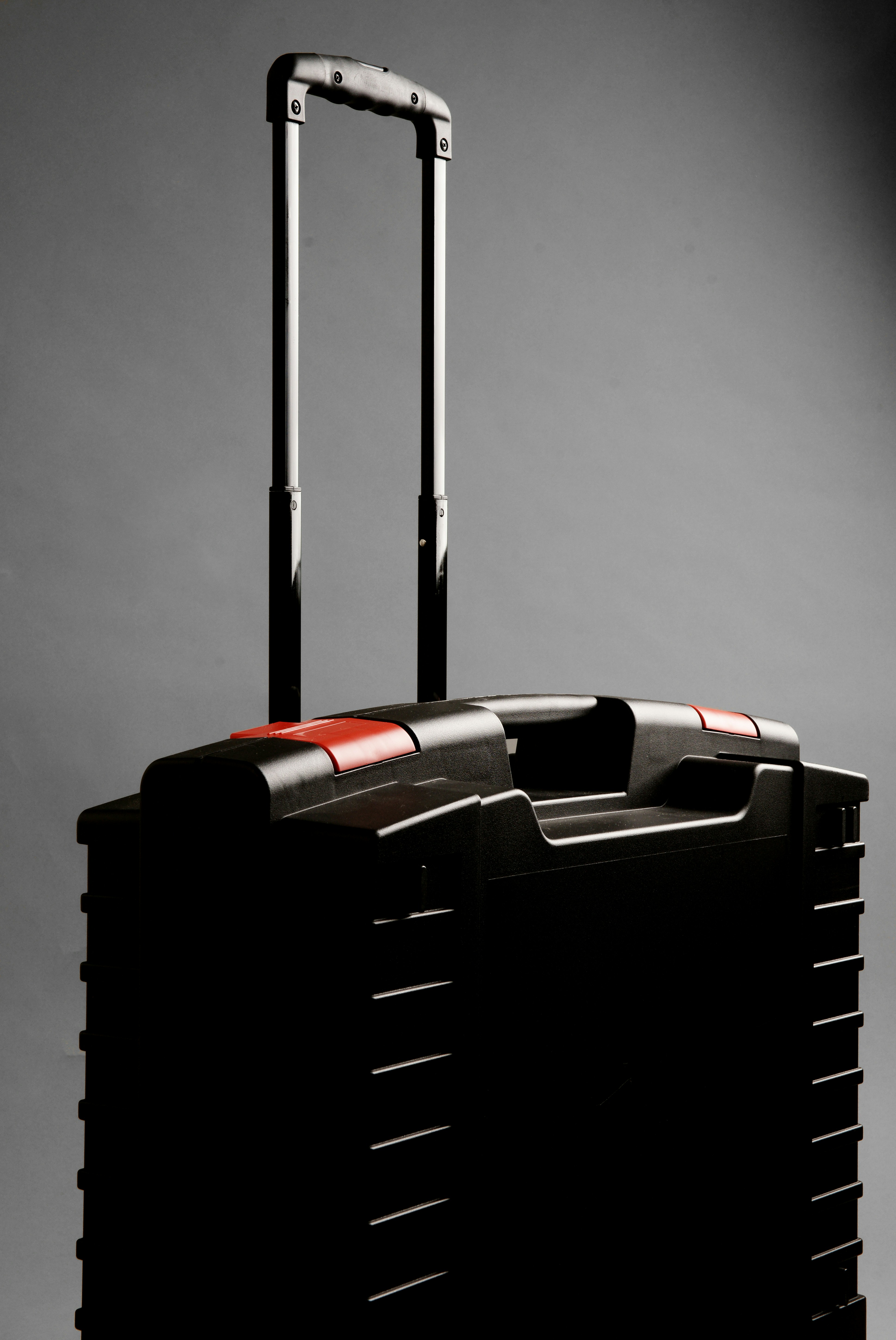 A black rolling suitcase with a telescopic handle