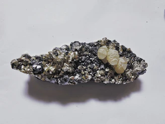 Cluster of pale yellow crystals on dark mineral matrix