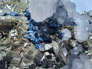 Close-up of metallic pyrite crystals with quartz and blue minerals