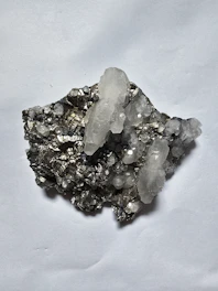 Clear quartz crystals on dark metallic mineral matrix
