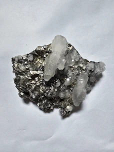 Clear quartz crystals on dark metallic mineral matrix