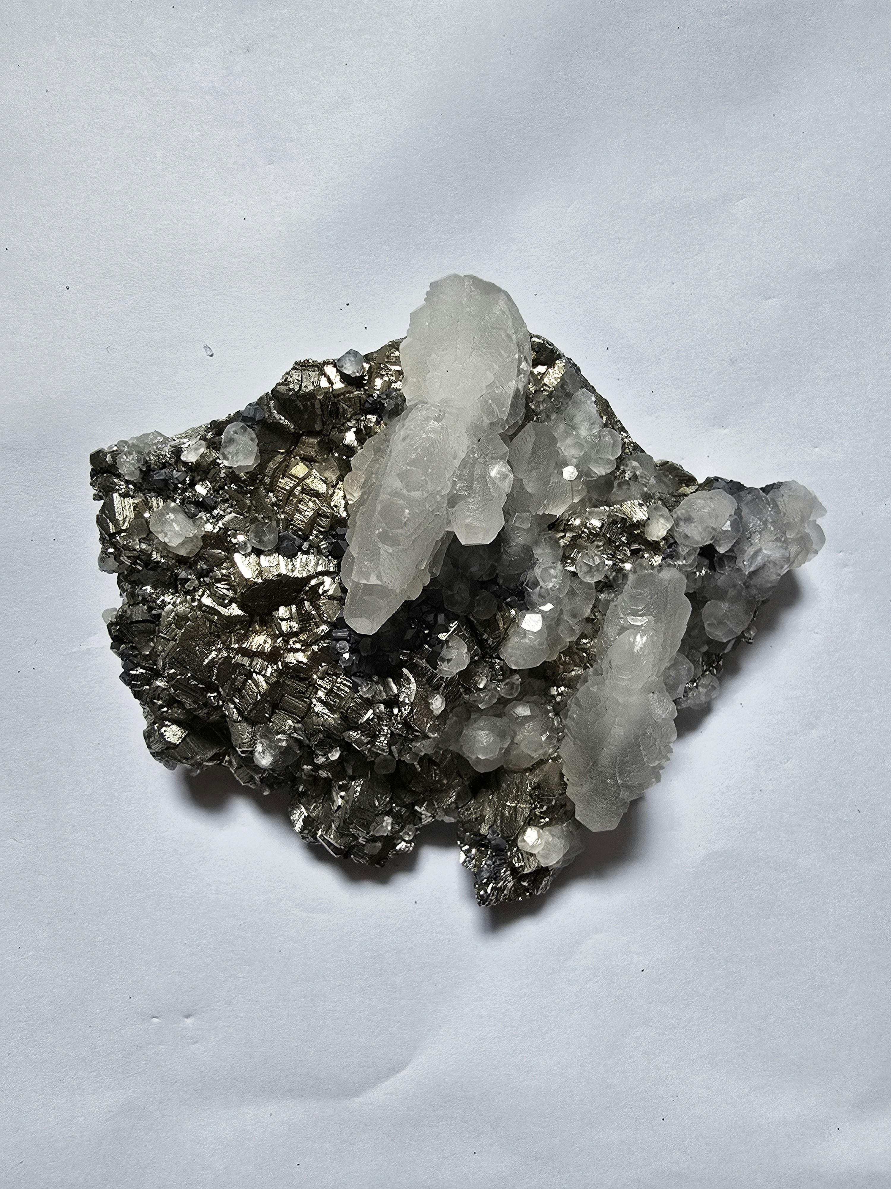 Clear quartz crystals on dark metallic mineral matrix