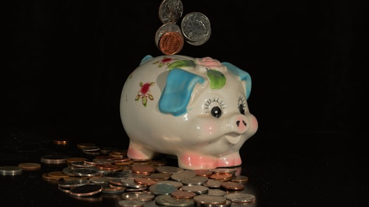 mynt som faller i en spargris, svart bakgrund