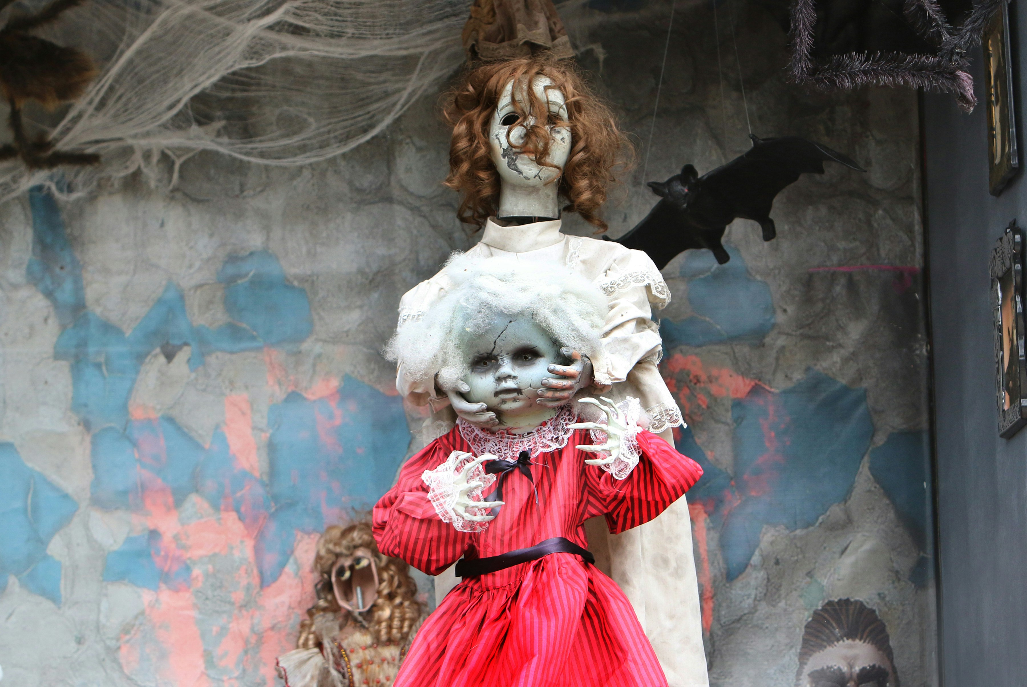 Two creepy dolls with tattered clothing and cobwebs