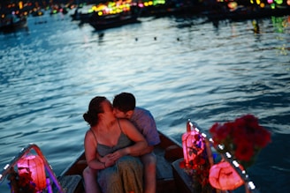 Couple kissing in a boat at night