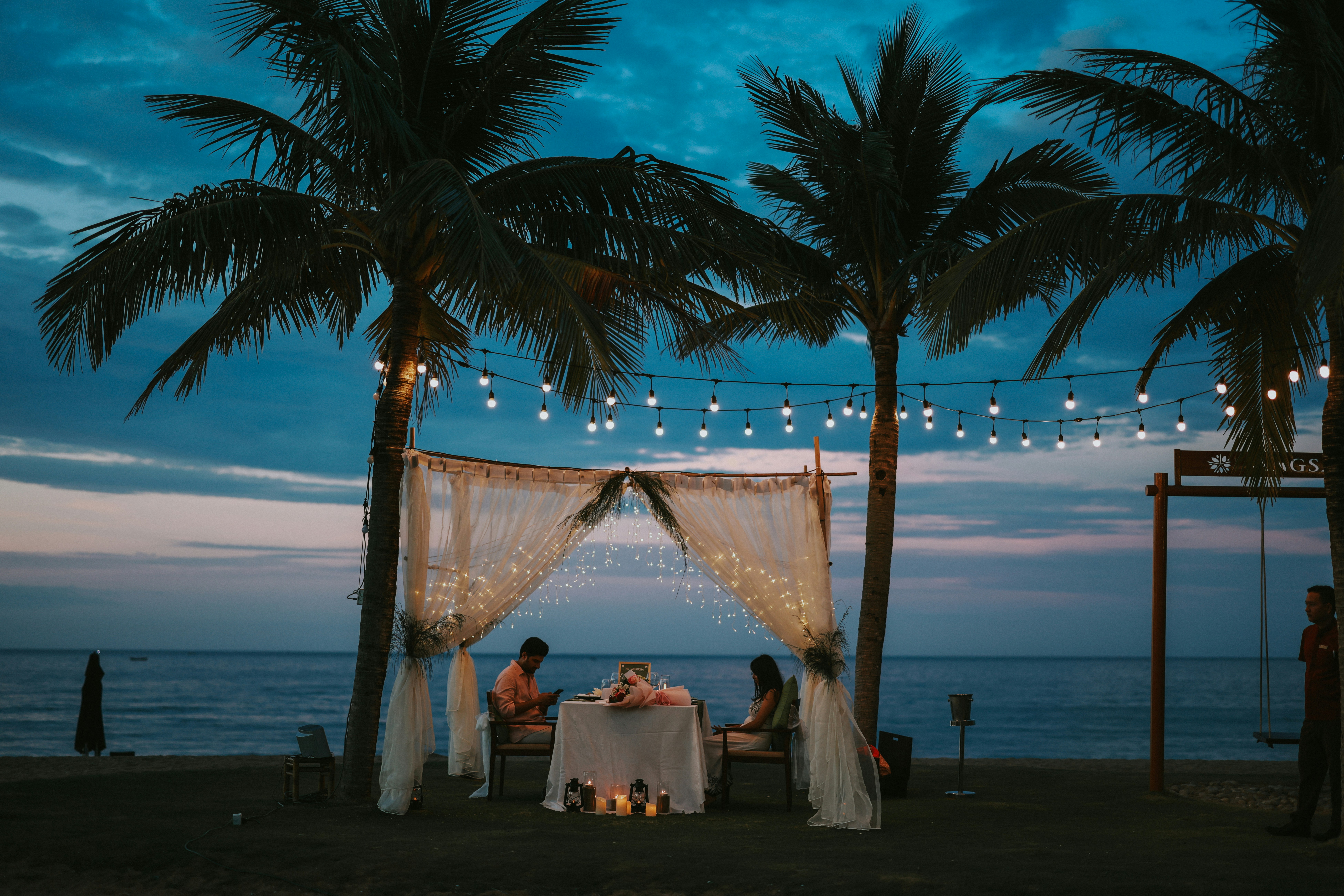 Romantic dinner setup on a beach at dusk