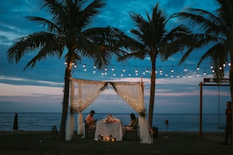 Romantic dinner setup on a beach at dusk