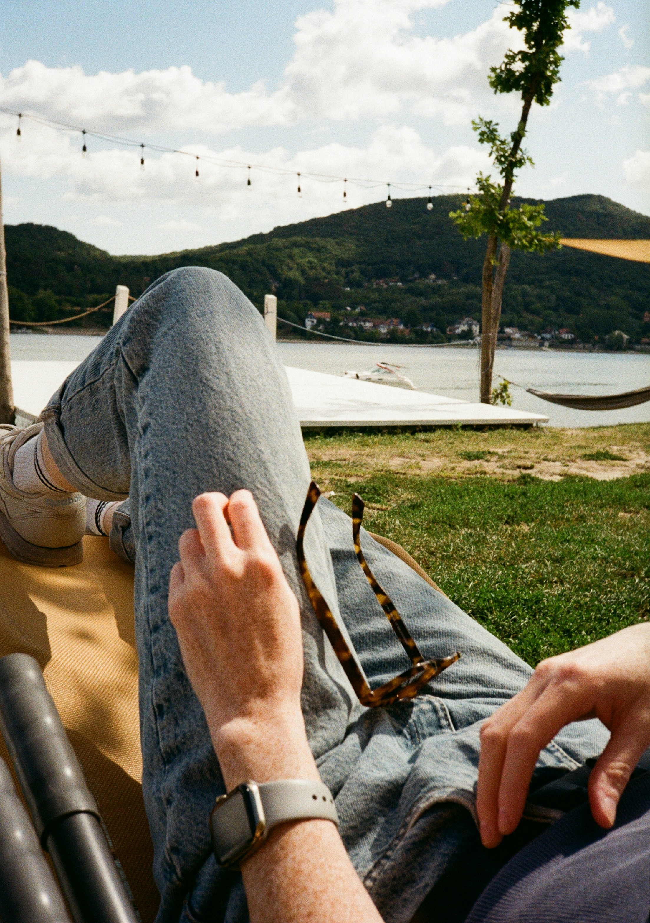 Person relaxing outdoors by the water on a sunny day