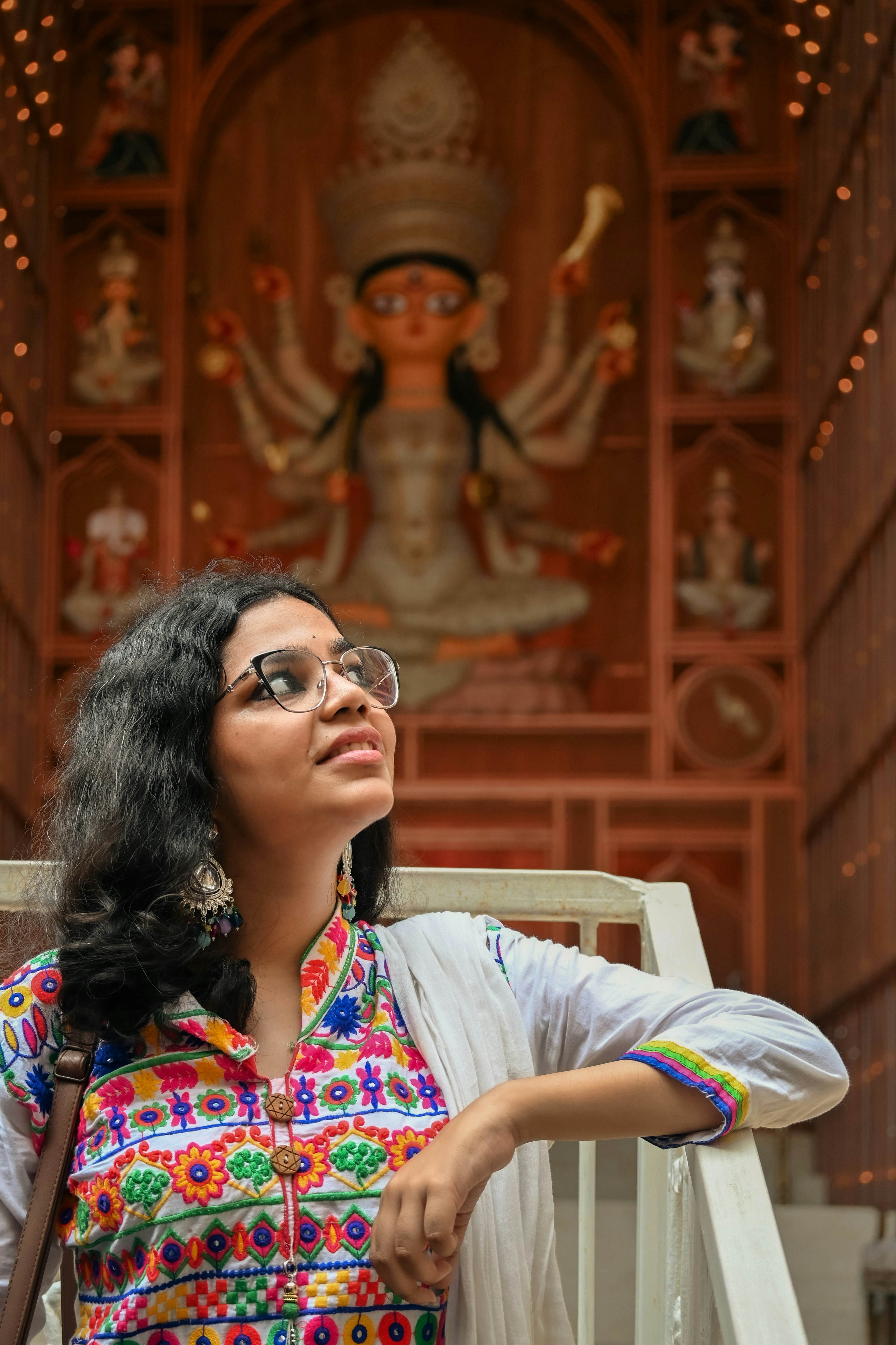 Woman looking up at deity statue in temple
