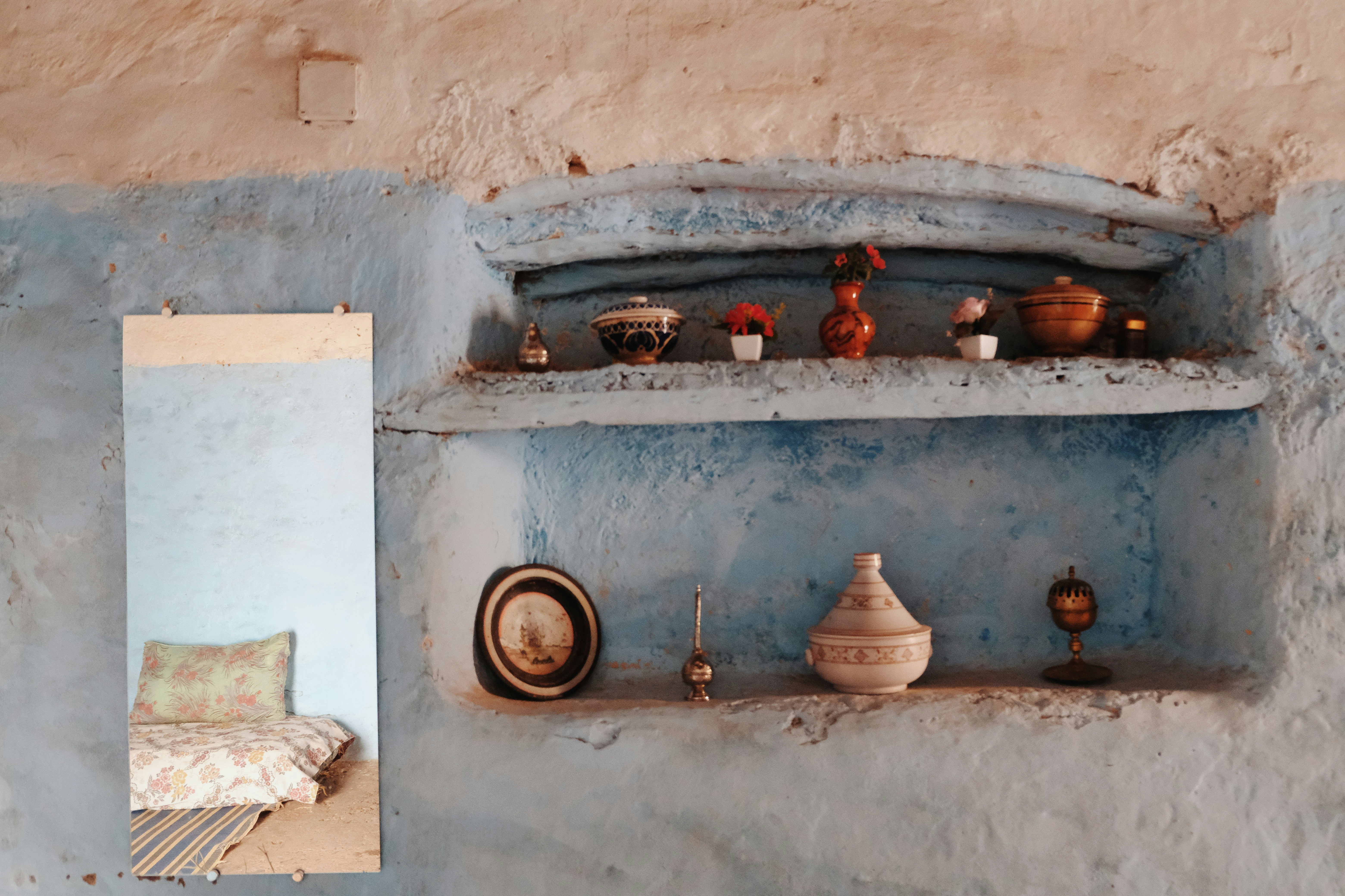 Shelves with decorative items and a mirror reflecting mirror