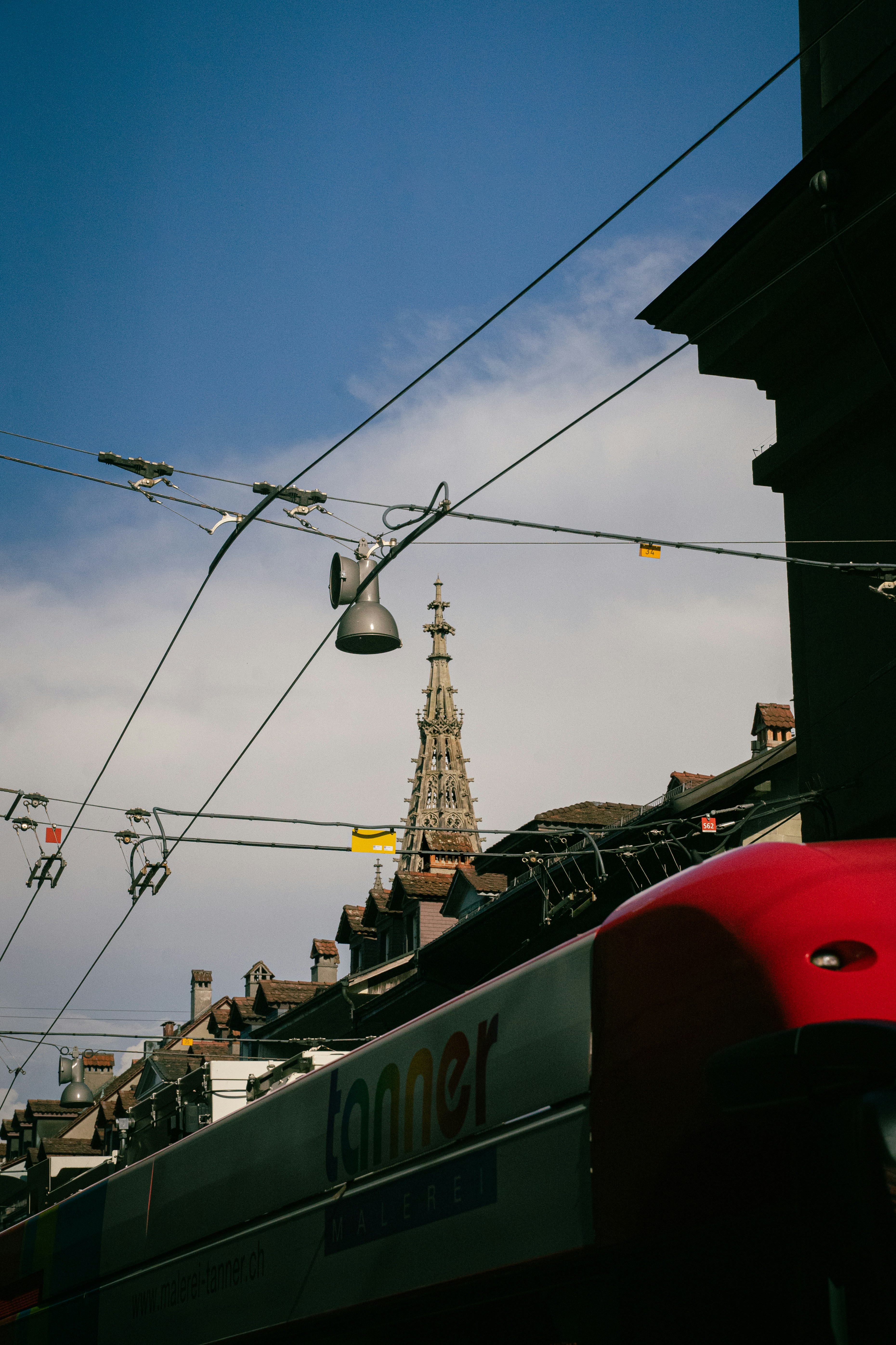 Trolleybus passes historic church spire in european city.