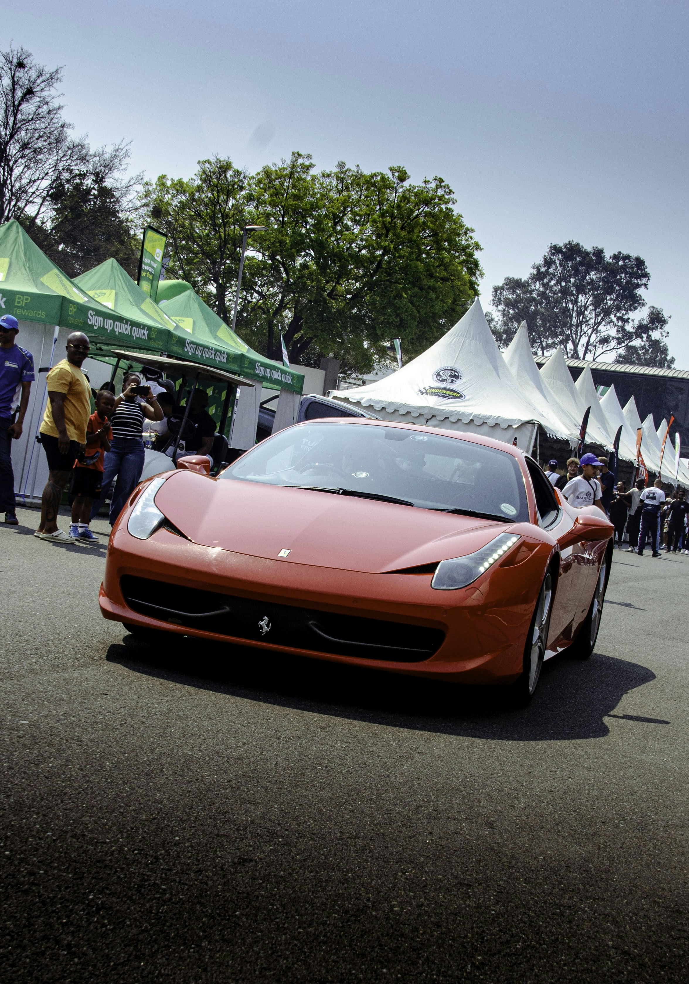 Una ferrari sportiva rossa che guida sull'asfalto
