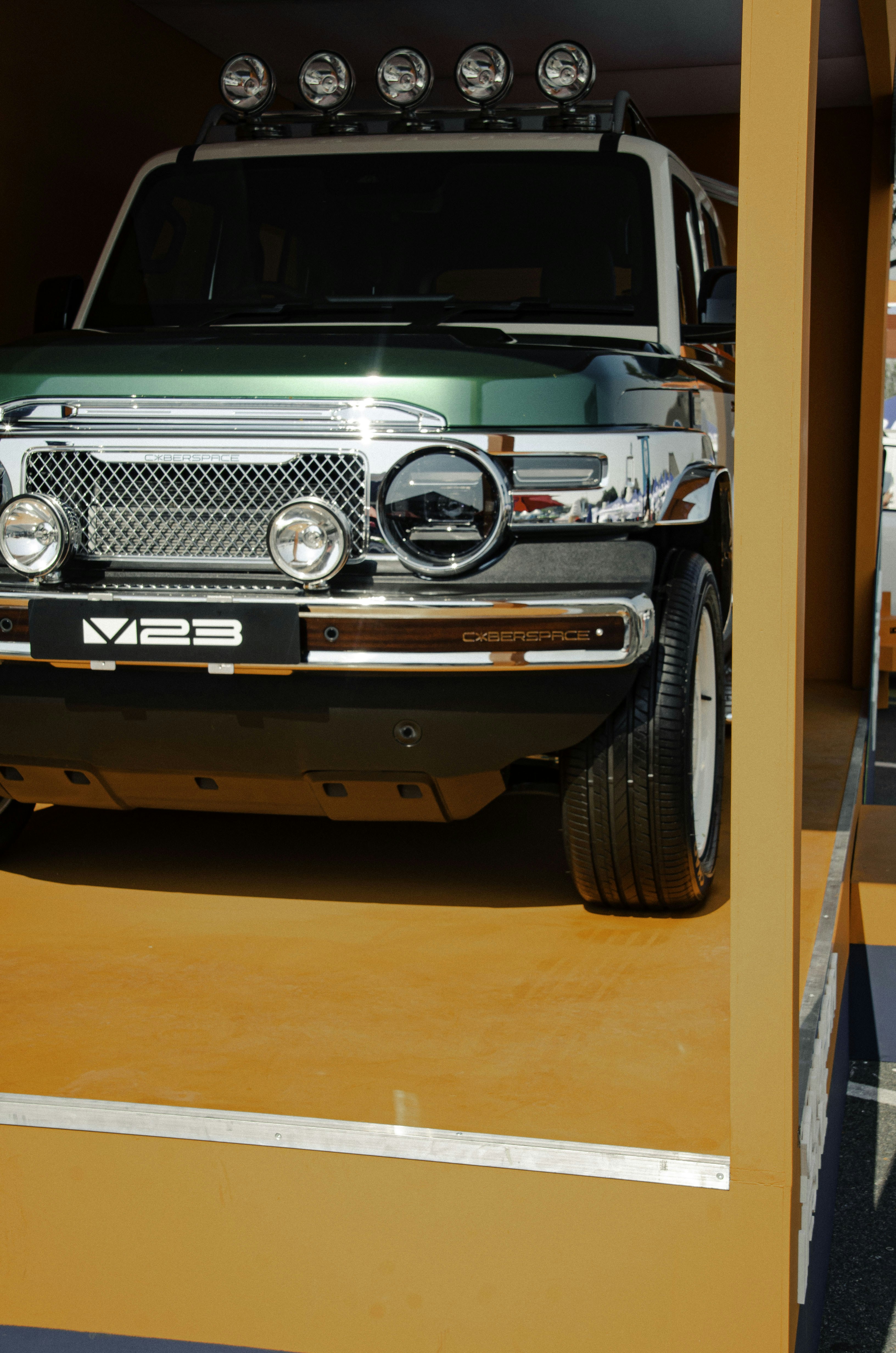 Green and white off-road vehicle with roof lights