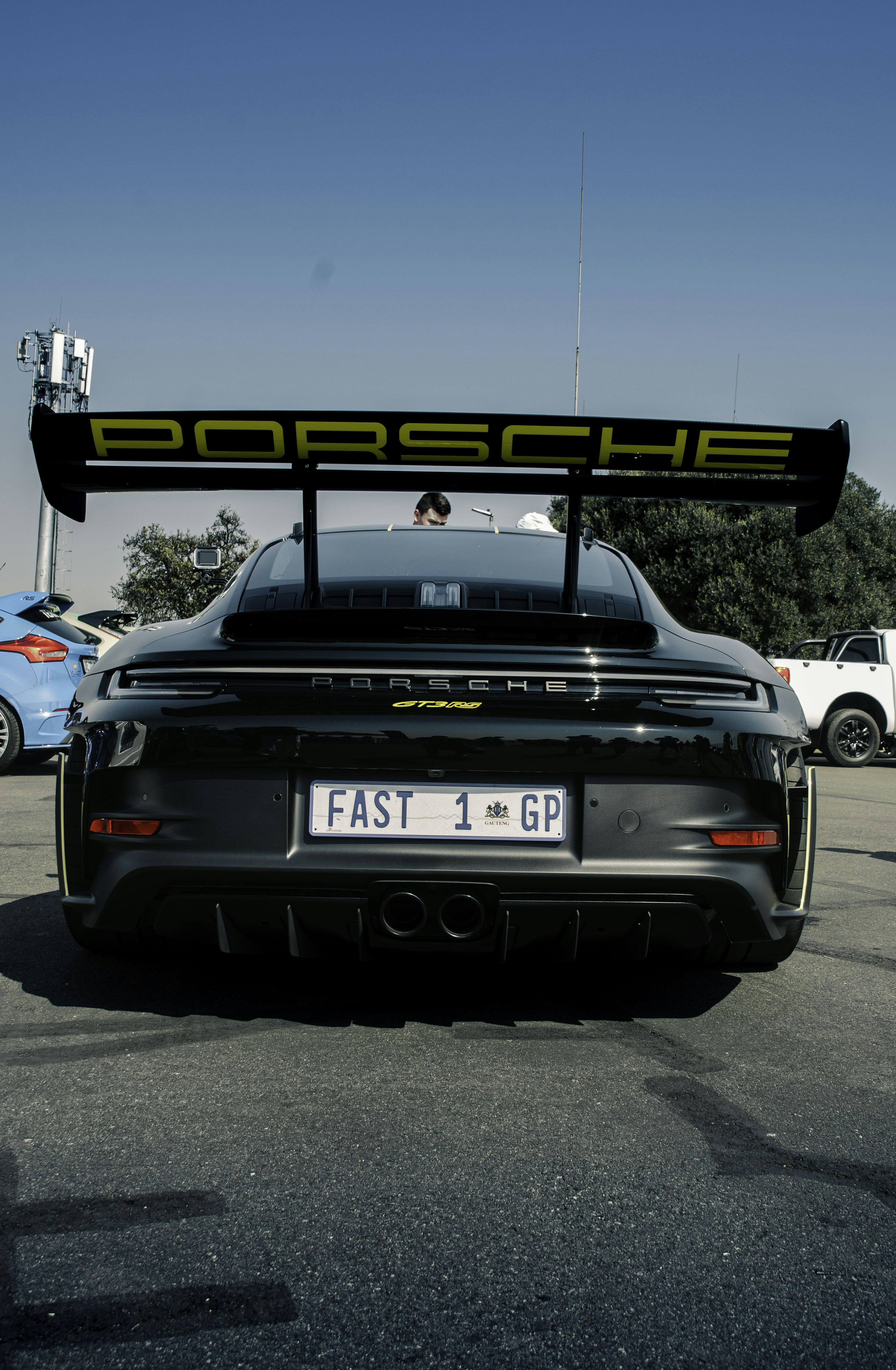 Black porsche with large yellow spoiler