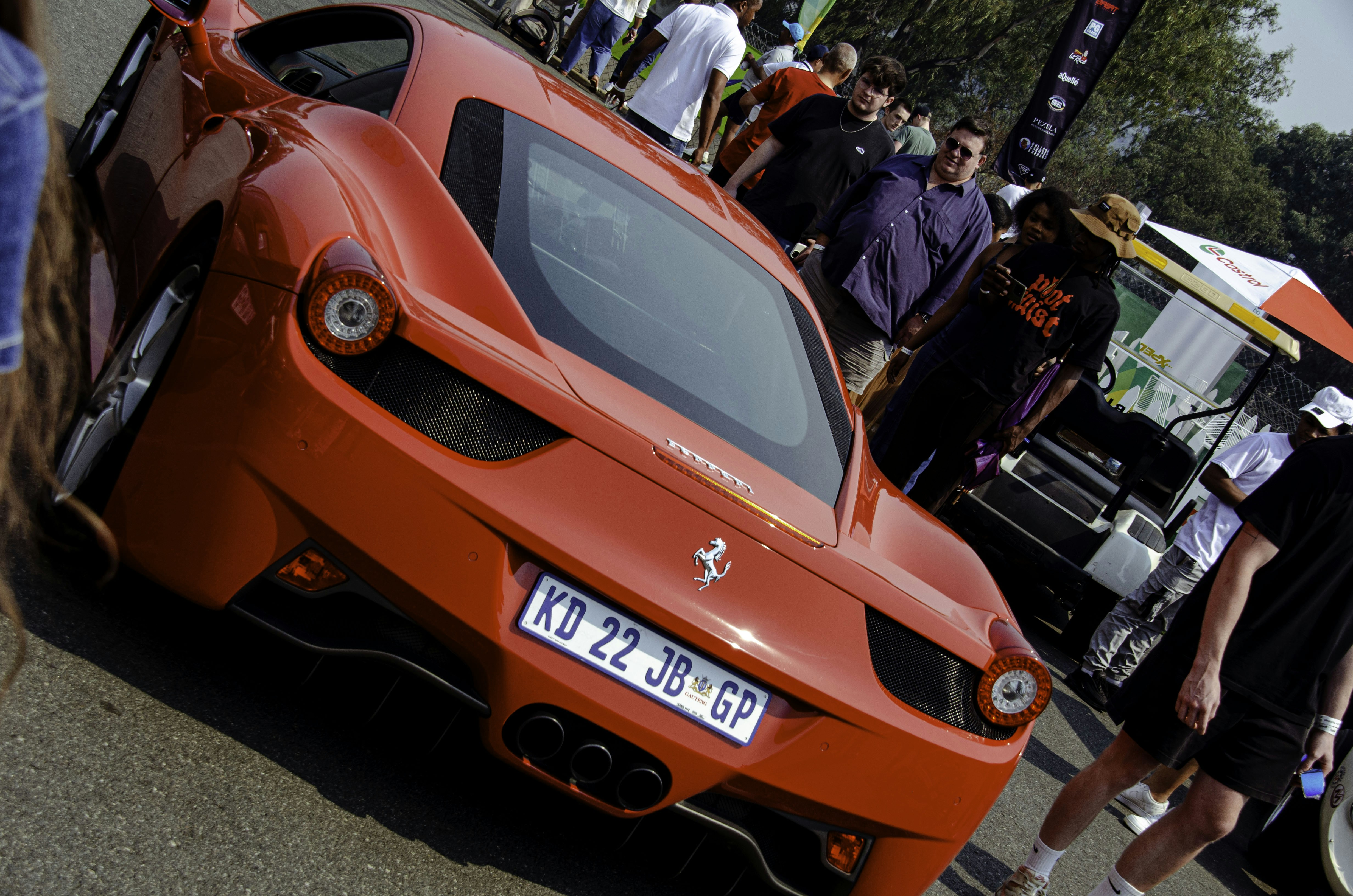 Red ferrari sports car with people in background