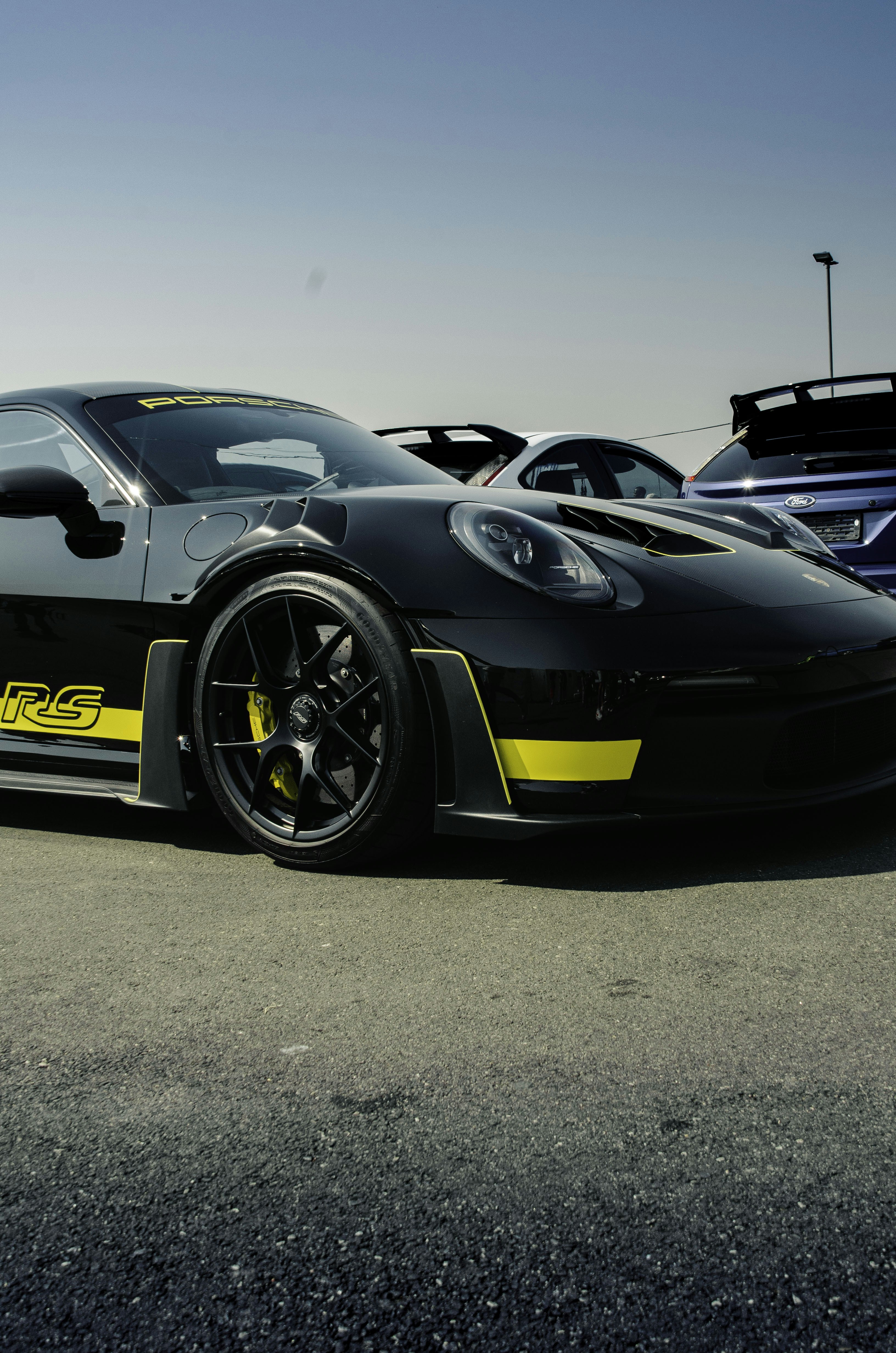 Black porsche gt3 rs with yellow accents on track
