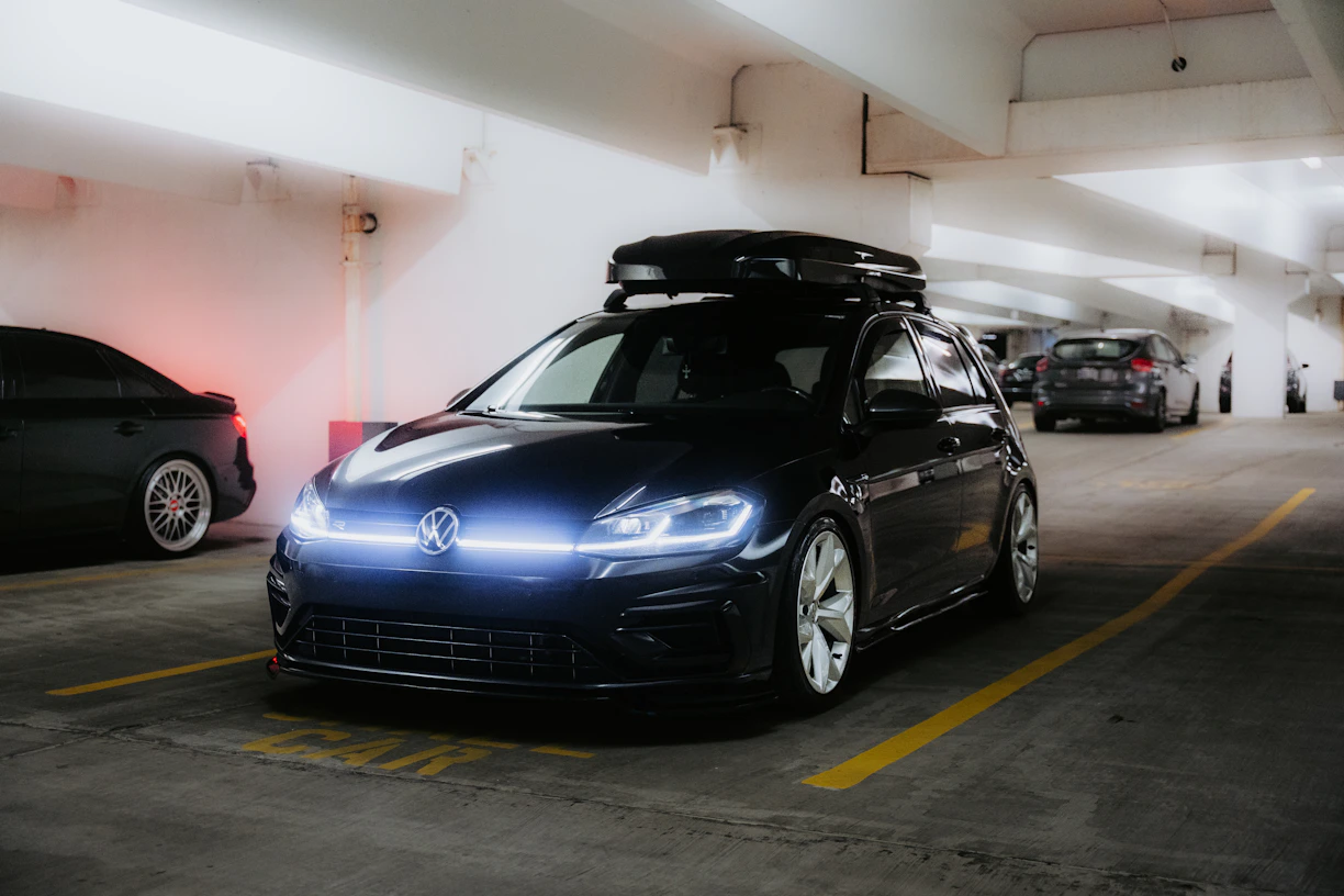 Black volkswagen golf r with roof box in parking garage