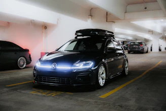 Black volkswagen golf r with roof box in parking garage