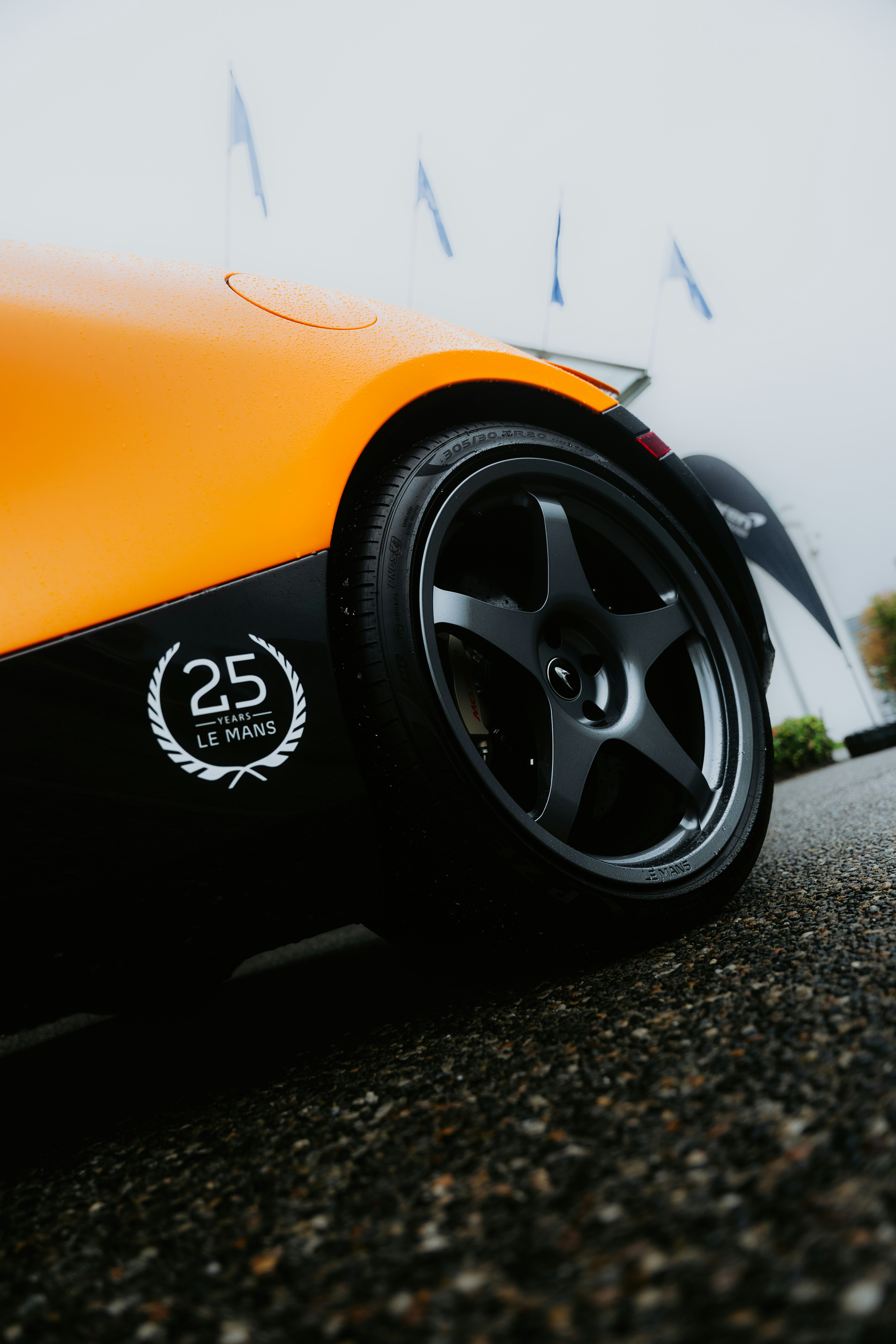 Coche de carreras naranja y negro con emblema "25 le mans".