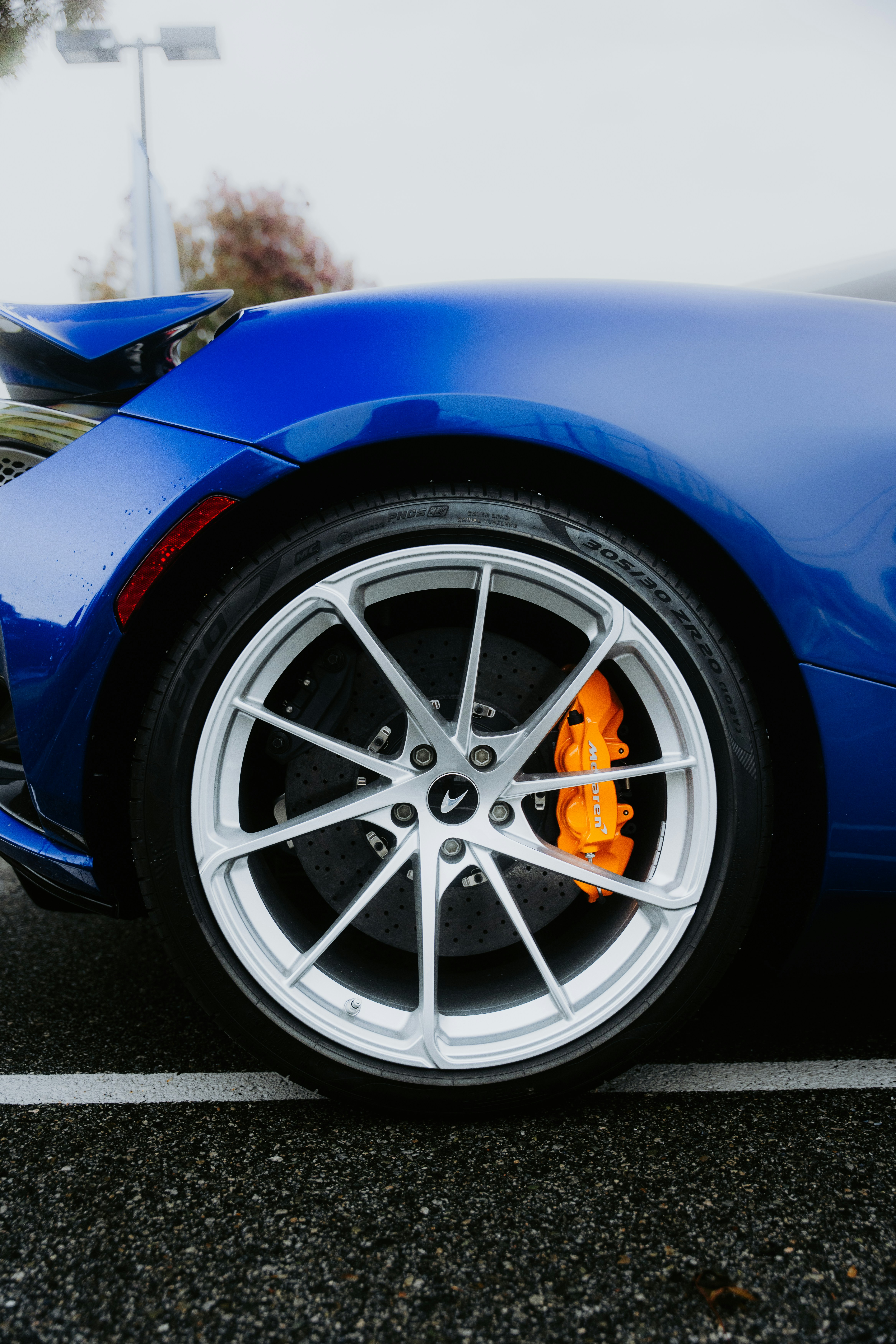 Close-up of a blue car wheel with orange brake caliper.