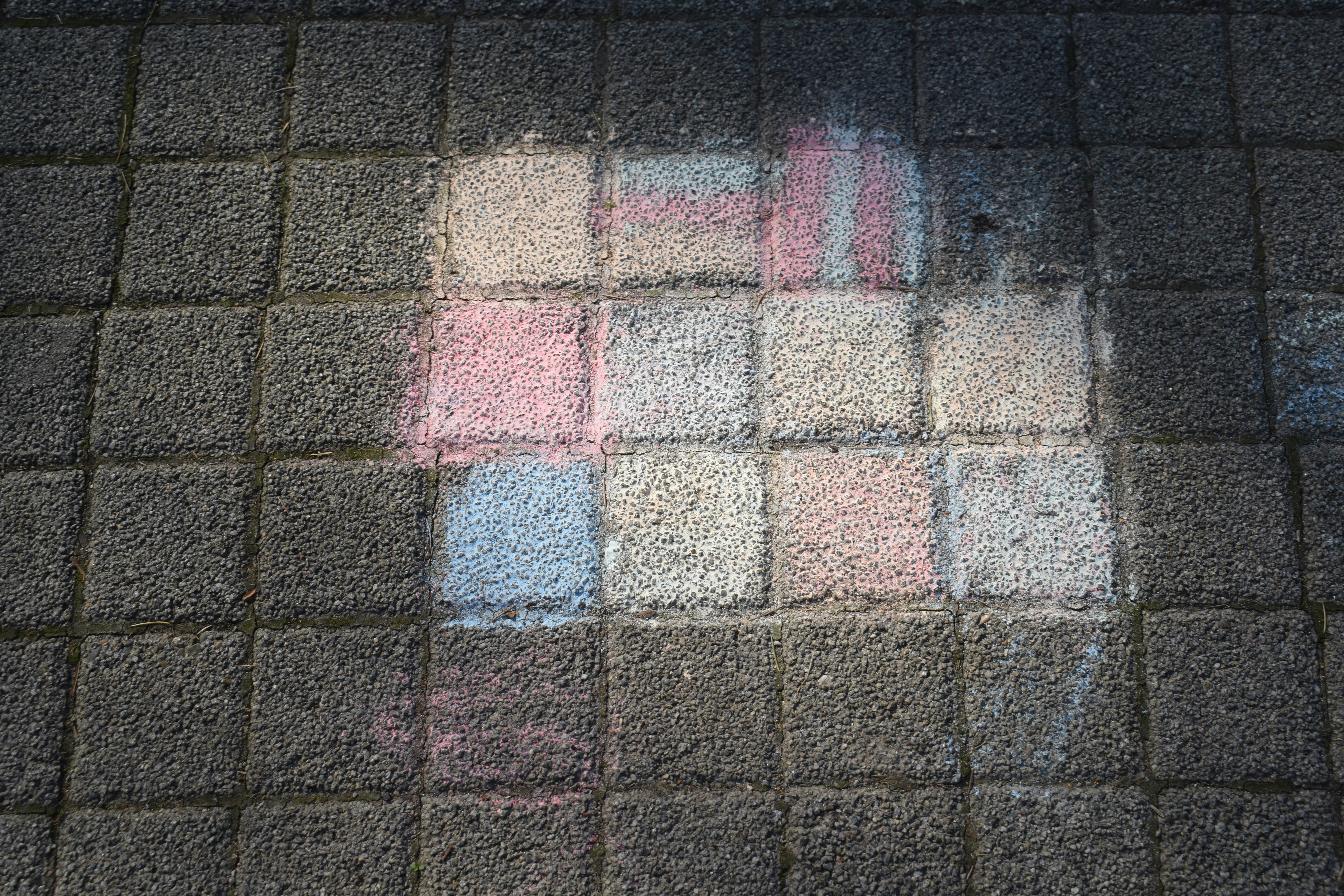 Chalk drawings on a tiled sidewalk