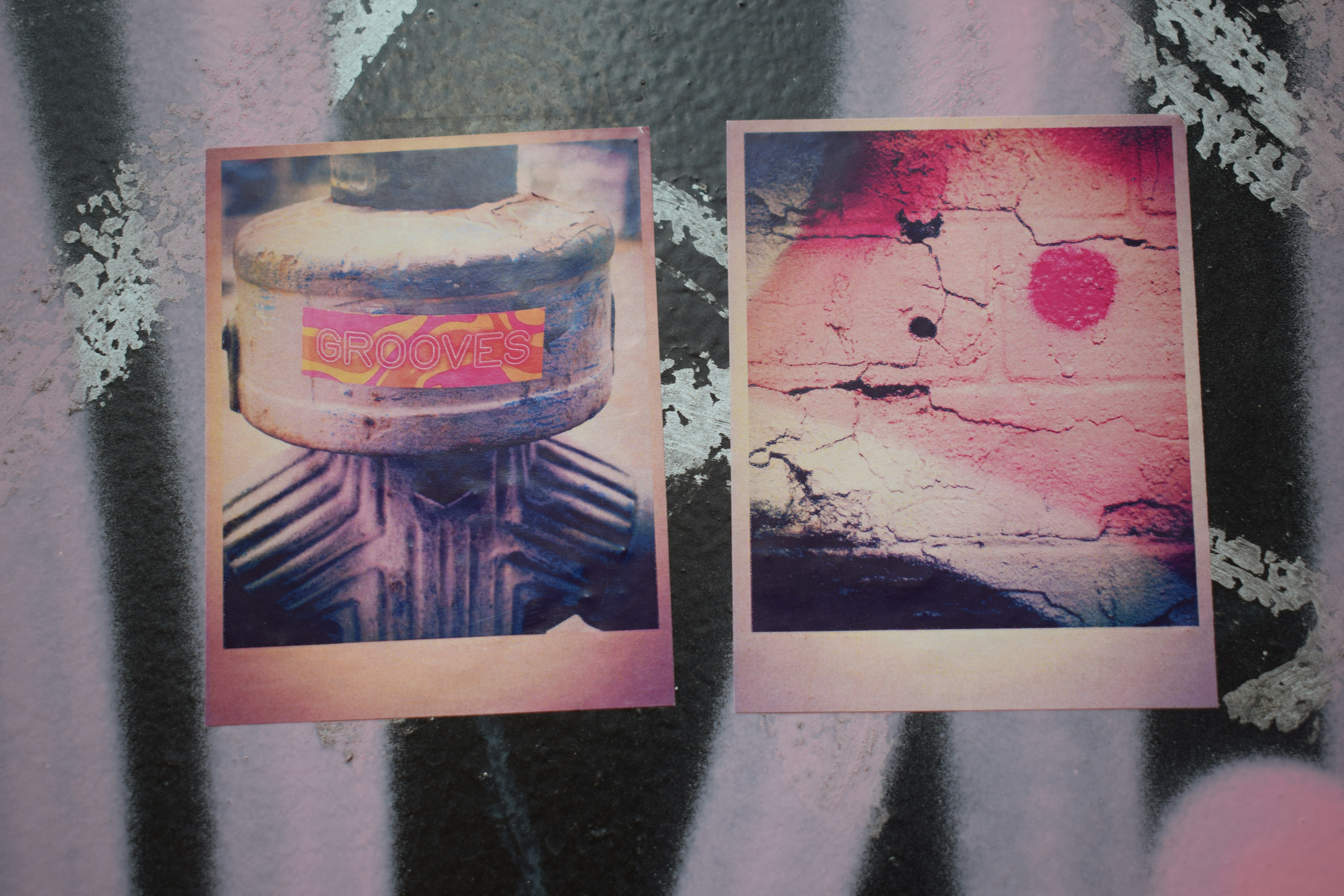 Two instant photos on a graffiti wall