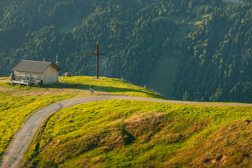 Small building on a grassy hillside with a winding path.