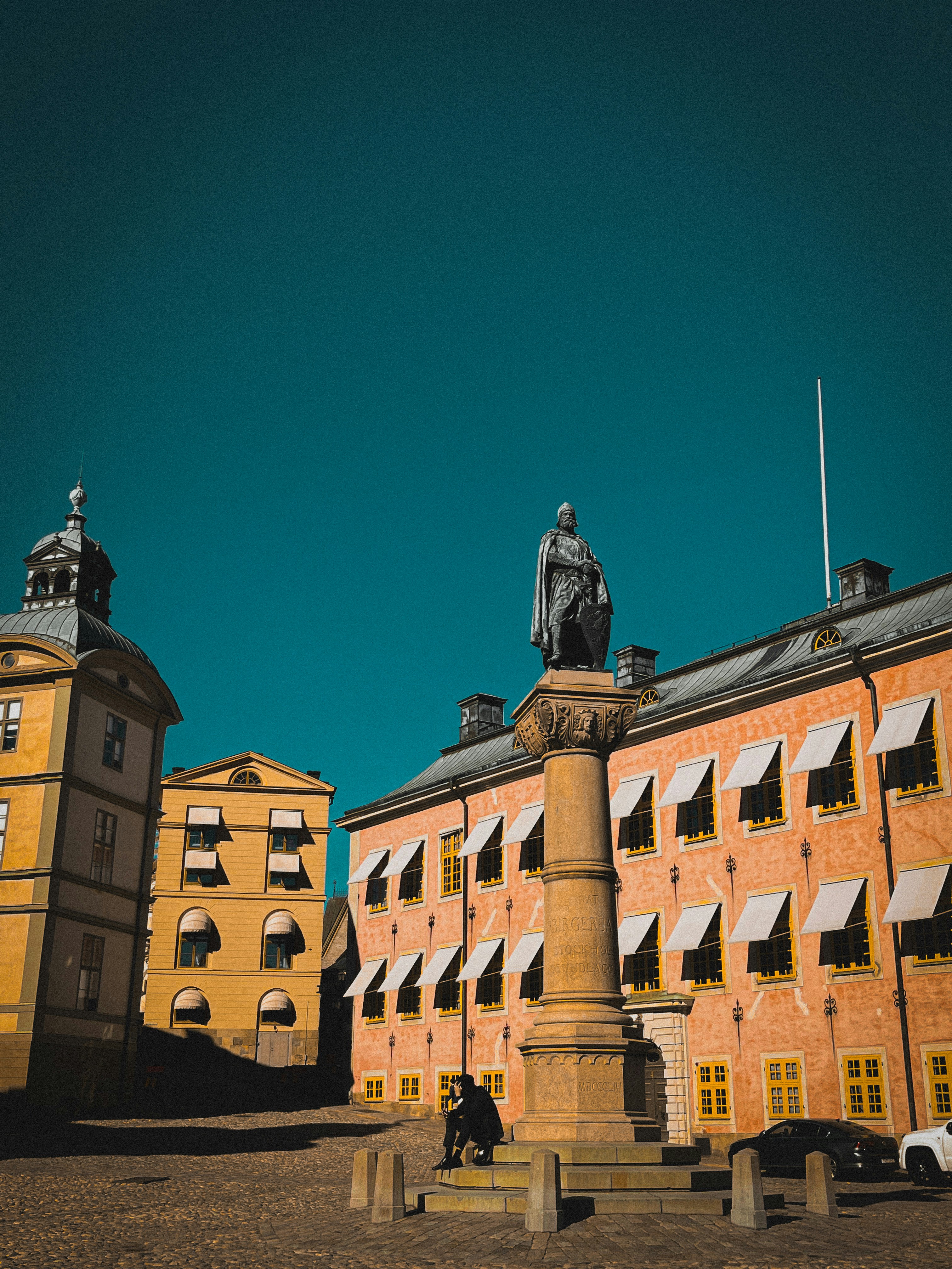 Statue in a town square with historic buildings.