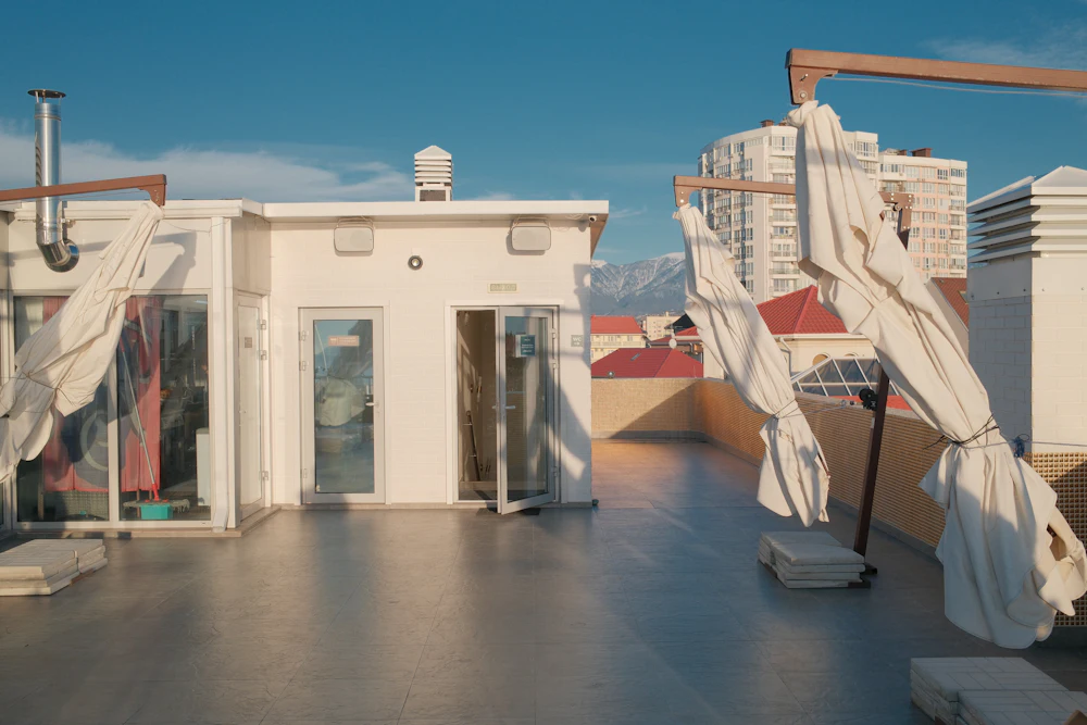 Terraço no topo de um edifício com grandes chapéus de sol
