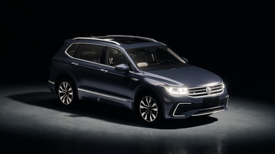 Dark blue suv parked in a studio with spotlights.