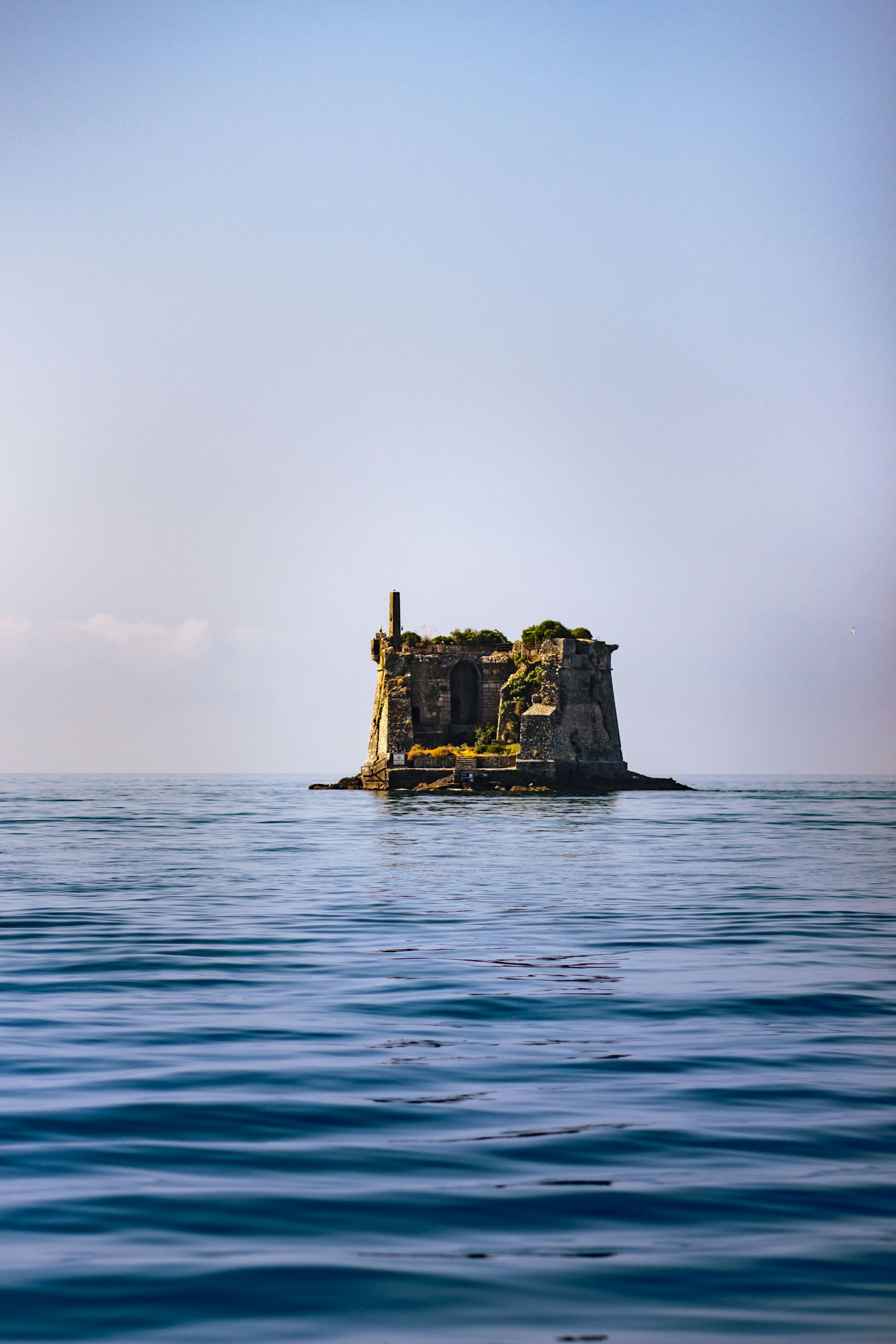 Ruined fortress on a small island in the ocean.